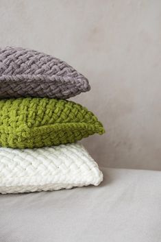 four knitted pillows stacked on top of each other