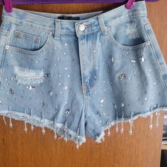 Hot Beautiful High-Waisted Light Denim Shorts Covered With Different Shape Icy Dazzling Rhinestones On The Front With Dangling Rhinestones Just Above The Hem Of Each Leg. Distressing On Both Back Pockets And Some On The Front Give These Feminine Shorts Just Enough Edge To Make Them Perfect! Great For Summer Parties Or Festivals. Minimal Stretch. Measurements: Waist - 15 In Length- 13in Inseam - 3 1/4in Materials: 73% Cotton 13% Polyester 13% Viscose 1% Other Fibers High Waist Rhinestone Denim Jeans, High Rise Denim Bottoms With Rhinestones, Trendy High Waist Embellished Bottoms, Trendy High Waisted Embellished Bottoms, Embellished High-waist Denim Bottoms, Trendy Embellished Denim Blue Bottoms, Blue High Waist Rhinestone Jeans, High-waist Blue Jeans With Rhinestones, High Waist Blue Jeans With Rhinestones