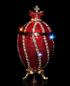 a red ornament with some lights on it's sides and a crown on top