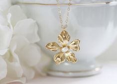 "This sweet little pendant necklace features a gold plated daisy flower hand wired wrapped with a creamy white fresh water pearl. Great gift for the flower lover in your life. Wonderful spring bridesmaid's necklace. Hangs from a fine 14 karat gold filled chain. Spring clasp closure The daisy is 1 \" wide ** The last photo show's a different pansy same size with a bird charm . Spring closure clasp Photoed with a 16\" chain on model H A N D M A D E * We hand make all pieces in our Water Mill New Y Flower Pearl Necklace, Gold Flower Necklace, Bridesmaid Pearls, Water Mill, Daisy Necklace, Necklace Flower, Modern Necklaces, Bridesmaid Necklace, Flower Jewelry