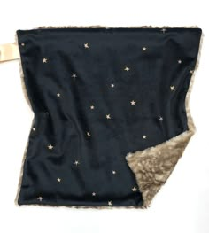 a black blanket with gold stars on it and a white ribbon hanging from the side