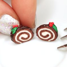 a hand holding a pair of tiny chocolate christmas pastries