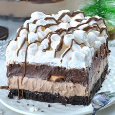 a piece of cake with marshmallows and chocolate on top is sitting on a plate