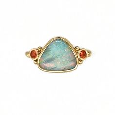 This Opal glows from deep within, from blue to green to pink, purple and orange. Set in 14k yellow gold with the most perfect orangesapphires. Accented with gold beads and Emily's seagrass band. Set in an opened back setting to allow maximum light play to pass through its flashy rainbow. Approx stone size: 12mm x 10mm Approx Ct weight: 1.9 cts Mohs Hardness 6 This piece is handmade to order in Emily's Hudson Valley studio. It is currently a size 7 but can be resized at no charge prior to shippin Orange Sapphire Ring, Australian Opal Ring, Purple And Orange, Orange Sapphire, Local Jewelry, Australian Opal, Hudson Valley, Opal Rings, Gold Beads