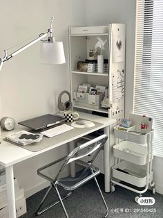 a white desk topped with a laptop computer next to a chair and window covered in blinds