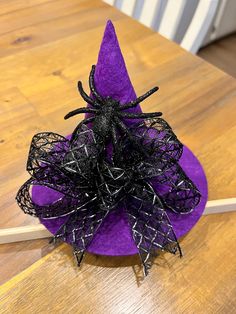 a purple hat with black spider decorations on it