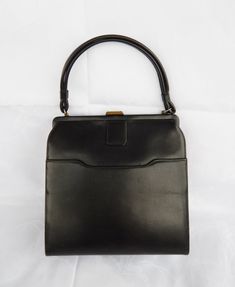 Vintage Black Handbag, Elegant Black Purse 1960's Classic Frame Bag Top Clasp, Mid Century Fashion  ♥ Beautiful true vintage c. 1960's handbag made of black faux leather with a beige vinyl interior. It has a doubled carrying handle and a brass top closure. One main compartment with interior zippered wall pocked and one exterior frontal slip pocket. This vintage purse is in a good condition: very clean, stain free interior, both the clasp and the interior zipper work great, there are surface scuf Vintage Square Box Bag, Vintage Rectangular Bags For Vintage Events, Vintage Black Bag For Vintage Events, Black Vintage Bags For Vintage Events, Vintage Bags With Hasp Closure, Retro Rectangular Evening Bag For Vintage Fashion, Vintage Rectangular Bags For Events, Vintage Bags With Hasp Closure For Daily Use, Vintage Bag With Hasp Closure For Daily Use