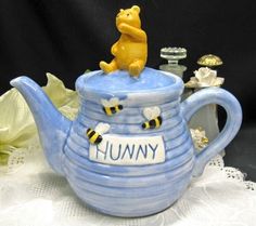 a ceramic teapot with a winnie the pooh figurine on top