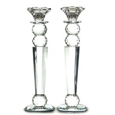 two clear glass candlesticks are standing next to each other on a white background