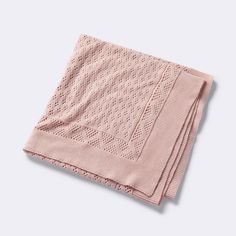 a pink knitted blanket folded on top of each other