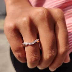 a close up of a person's hand with a diamond ring on their finger