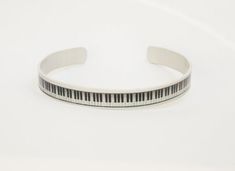 Piano keyboard cuff bracelet, black and brushed silver. This is a great pianist/ musician gift! I'm a pianist and wear this a lot. :) My design is dyed and heat sealed by me on this aluminum bracelet. The process allows the colors to become part of the material, making it durable and scratch resistant. The cuff is lightweight, waterproof, and slightly flexible, allowing it to be adjusted for a perfect fit. It is exceptionally comfortable to wear and will never tarnish or discolor your skin.  It Piano Bracelet, Blue And White Rings, Feather Cuff Bracelet, Olive Leaf Ring, Aluminum Bracelets, Key Bracelet, Boho Cuff, Piano Keyboard, Piano Keys