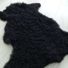 a black sheepskin rug is laying on the floor