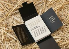 a black and white book laying on top of some dry grass next to a pile of straw