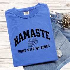 Namaste Shirts Make Great Gifts AND they make a statement! These fun and meaningful shirts will be a big hit with your friends and family as you spread good vibes and smiles. T-SHIRT:  COMFORT COLORS 1717® *Unisex sizing (size chart for your ideal fit) *100% ring-spun cotton *Preshrunk, soft-washed, garment-dyed fabric *Double-needle stitching for durability & shape retention *Twill taped shoulder-to-shoulder *1" ribbed collar with double-needle topstitched neckline *No side seams *Sewn-in twill Bookish Crew Neck T-shirt With Letter Print, Bookish Short Sleeve T-shirt With Funny Text, Bookish Cotton T-shirt With Letter Print, Relaxed Fit Pre-shrunk Bookish T-shirt, Bookish Cotton T-shirt With Slogan, Bookish T-shirt With Funny Text And Crew Neck, Short Sleeve T-shirt With Funny Text, Bookish Crew Neck Shirt With Letter Print, Relaxed Fit Bookish Tops With Text Print