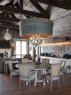 a dining room table with chairs and a chandelier hanging from it's ceiling