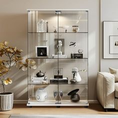 a living room filled with furniture and a glass case on top of a wooden floor