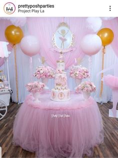 a pink and white cake on top of a table with balloons in the background at a princess birthday party