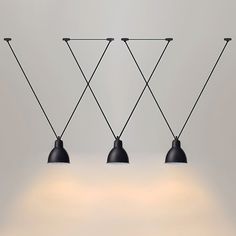 three black lamps hanging from the ceiling with one light on each side and two behind them