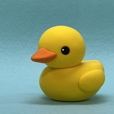 a yellow rubber ducky sitting on top of a blue surface with its head turned to the side