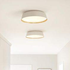 two lamps are hanging from the ceiling in a room with white walls and flooring