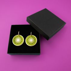 These perfect circles of symmetry scream fun in a delightfully juicy way. A beautiful combination of greens, the flashes of gold and pearly white add to the elegance of this kiwi earring.  The kiwis hang and sway from elegant 22mm gold-filled hoops, and are removable so you can wear the hoops on their own—two earrings in one, perfect for travel! Wipe clean with a damp cloth. Do not submerge in water. Keep away from extreme heat. Modern Green Round Earrings, Modern Green Earrings As Gift, Trendy Lime Green Jewelry For Gift, Trendy Lime Green Jewelry Gift, Trendy Lime Green Jewelry As A Gift, Green Earrings For Summer Gift, Elegant Green Circular Earrings, Kiwi Earrings, Frosted Mirror