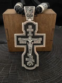 "Silver cross with ebony wood. Art. 0178 ✔️925 silver with blackening + ebony wood ✔️Size 80/39.6 mm ✔️Weight 54 grams ✔️The cross depicts: 🔘Jesus Christ 🔘Mother of God 🔘Nicholas the Wonderworker 🔘Vladimir the Great 🔘Panteleimon the Healer 🔘Guardian Angel ✔️On the end is the complete prayer \"Our Father\" ✔️Possible production in: 🟡Gold 14K or 18K (red, yellow, white) 🌕24K gold plated sterling silver 🔘Silver with blackening or rhodium Need more information? If you have any questions please don't hesitate to contact us!" Black Engraved Crucifix Necklace, Black Crucifix Necklace Engraved, Black Engraved Cross Jewelry, Black Engraved Cross Pendant Necklace, Black Engraved Pendant Cross Necklace, Engraved Black Cross Necklace As Gift, Black Sterling Silver Cross Necklace For Gift, Black Engraved Cross Necklace Gift, Engraved Black Cross Necklace For Gift