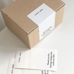 three pieces of white paper sitting on top of a table next to a box and envelope