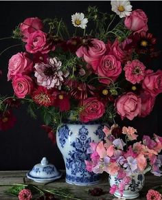 a blue and white vase filled with lots of flowers