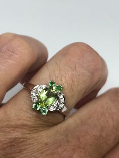 Rich and very bright Peridot, green chrome diopside white white sapphire ring Sterling silver with rhodium finish Size 6.75 can be sized by my jeweler. His service charge is $10-$20 All rings are shipped in a nice gift box. Check out our over a THOUSAND great reviews Engraving is $4 per letter and is not always perfect depending on the piece. It can take a few days if the jeweler is busy. This is payable to Paypal Judithsltd@gmail.com Green Peridot Birthstone Gemstones, Green Peridot Gemstones As Birthstones, Peridot Gemstones For Anniversary, May Birthstone, Peridot Gemstones For Anniversary - May Birthstone, Green Diamond Gemstones For May Birthstone, Green Gemstones For Promise Rings, Green Gemstones With Prong Setting For May Birthstone, Green Tsavorite Jewelry With Accent Stones, Green Peridot Multi-stone Jewelry