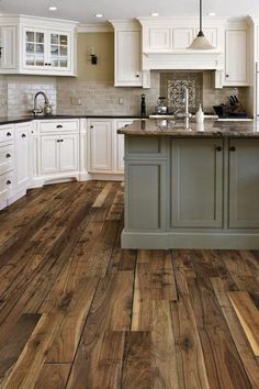 a kitchen with wooden floors and white cabinets