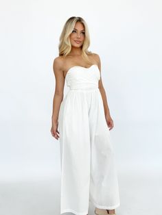 Effortlessly elegant, this versatile jumpsuit is perfect for any summer occasion. The bright and coastal design, featuring a lined and wide leg silhouette, makes it the perfect choice for a wedding, vacation, or resort getaway. The tie detail and strapless design exude luxury and style, while the stretchy smocked back panel ensures both comfort and a flattering fit. With pocket details for added convenience, this jumpsuit is a must-have for your summer wardrobe. Self 100% Cotton Lining 100% Poly Coastal Design, Summer Breeze, New Tops, Summer Wardrobe, Dress Collection, American Girl, A Wedding, Smocking, New Dress