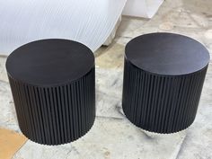 two black round tables sitting on top of a floor