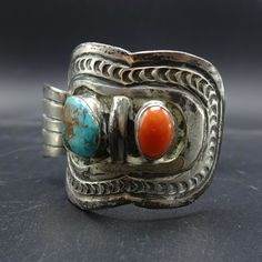 "VINTAGE NAVAJO WATCH CUFF DESCRIPTION: Beautiful blue turquoise and old red Mediterranean coral cabochons set in heavy gauge, hand stamped sterling silver. If you intend to use this as a vehicle for your watch, it may require further reconditioning. This watch cuff will be a cherished addition to your collection of fine vintage Native American jewelry. MEASUREMENTS: Interior of the cuff measures 5 7/8\" with an additional 1 3/8\" slightly adjustable gap. Total circumference: 7 1/4\" Measures 2 Vintage Turquoise Cuff Bracelet With Concho, Vintage Turquoise Concho Cuff Bracelet, Red Sterling Silver Vintage Bracelets, Vintage Collectible Cuff Bracelet With Polished Finish, Vintage Silver Cuff Bracelet With Concho, Vintage Silver Bracelets With Concho, Vintage Sterling Silver Concho Cuff Bracelet, Vintage Concho Cuff Bracelet For Gift, Vintage Concho Cuff Bracelet Gift