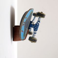 a skateboard hanging from the side of a wall with wheels attached to it's sides