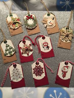 several tags with christmas decorations on them are hanging from twine string and decorated with snowflakes