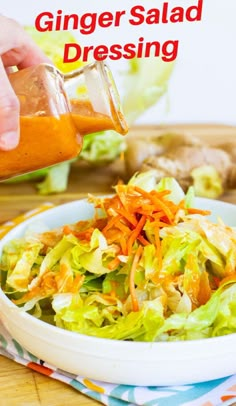 a person pouring dressing into a salad in a bowl with lettuce and carrots