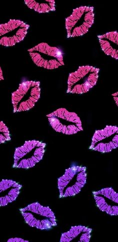 many pink and purple lipstick are arranged in the shape of lips on a black background