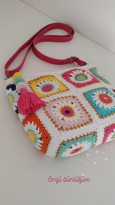 a crocheted purse with tassels on the front and side, sitting on a white surface