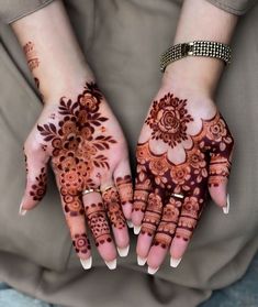 two hands with henna designs on them