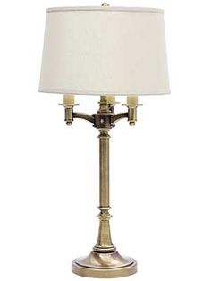 a lamp with a white shade on top of it and a light bulb in the middle