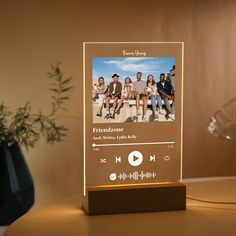 an illuminated music player on a table next to a potted plant