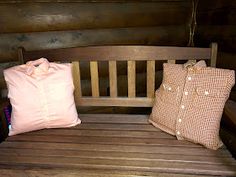 two pillows sitting on top of a wooden bench