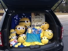 the back end of a car with stuffed animals in it's trunk, all dressed up as minions from despicables