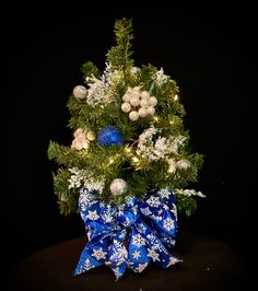 a small christmas tree with blue and white decorations