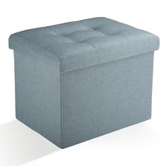 a blue storage ottoman with buttons on the top and bottom, sitting in front of a white background