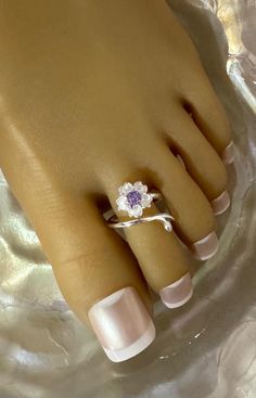 This silver toe ring features a a brilliant silver flower that cups up and has a purple crystal accent in the center . This toe ring is size adjustable and one size fits most. Comfortable and versatile, it will lend itself to casual or formal events. All items are made in a smoke free environment. *If there is any issue with your toe ring, please let me know so I can correct it. Thanks for visiting my shop!👣 Toe Ring Designs, Columbia Tn, Sterling Silver Toe Rings, Ring Purple, Silver Toe Rings, Purple Crystal, Toe Ring, Purple Crystals, Crystal Flower