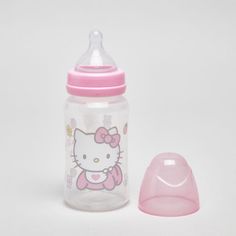 a pink hello kitty sippy cup next to a baby's pacifier on a white background