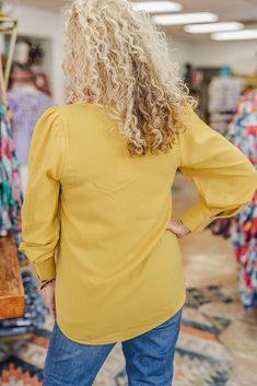 Solid top with a V-neckline, long puffed bubble sleeves and buttoned cuffs.- Unlined, non-sheer, lightweight. Paired with our Give A Little Judy Blue Jeans! Available in Sizes Small, Medium, Large Michaelle is wearing a small Fabric: 100% Polyester Color: Mustard Balloon Sleeve Top With Gathered Sleeves For Day Out, Fall V-neck Blouse With Pleated Sleeves, Spring V-neck Blouse With Button Cuffs, Fall V-neck Top With Elastic Sleeves, Fall V-neck Puff Sleeve Top With Blouson Sleeves, V-neck Top With Button Cuffs For Day Out, Blouson Bishop Sleeve Blouse For Brunch, Bishop Sleeve Blouse With Blouson Sleeves For Brunch, Brunch Blouse With Blouson Bishop Sleeves