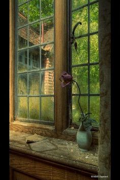 a painting of an old window with a vase on the windowsill and a house in the background